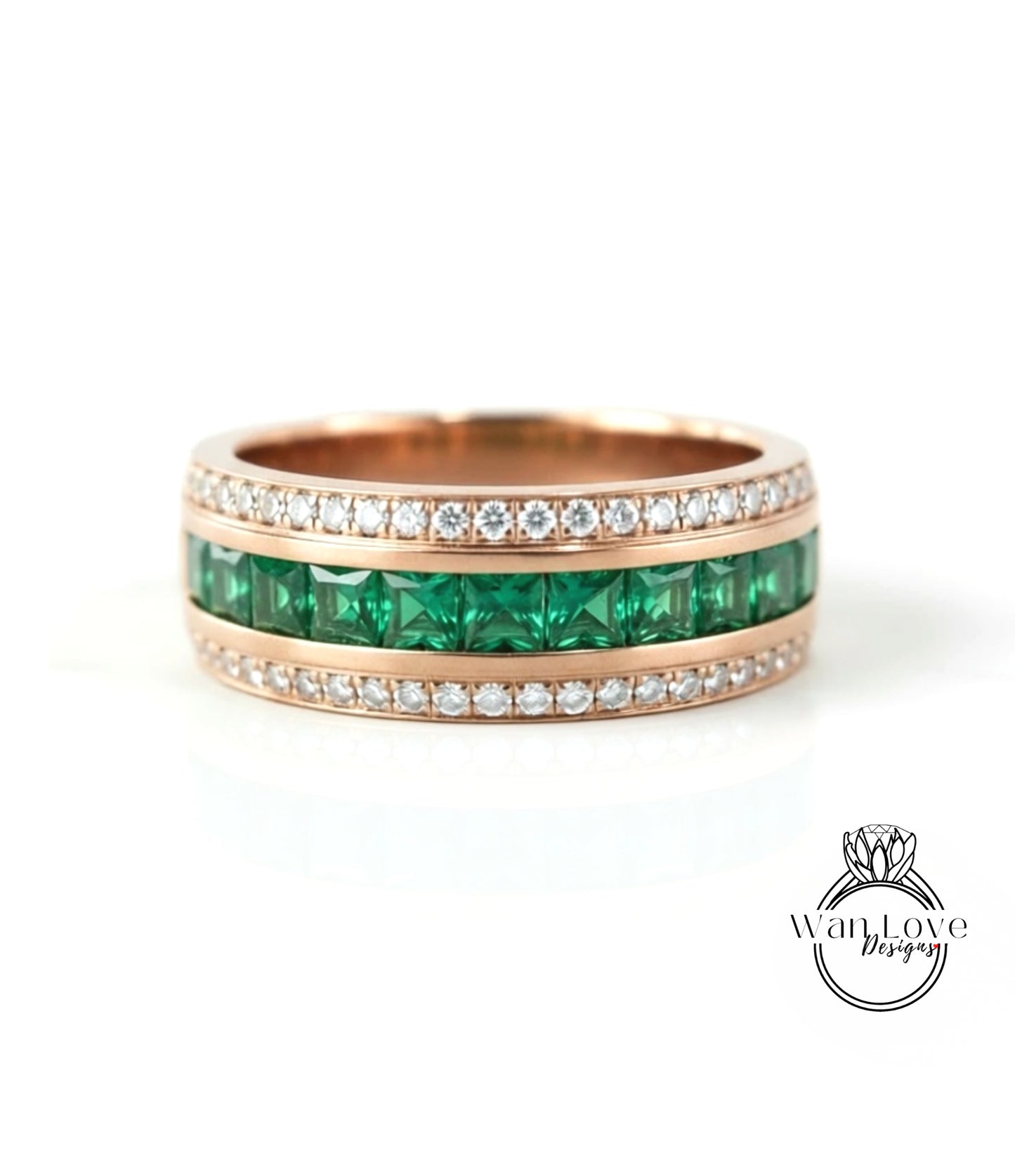 A gold ring with a row of green gemstones, including diamonds, set in a band.