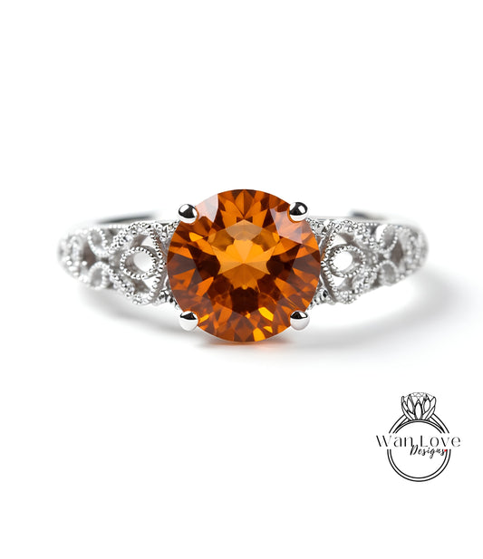 a ring with a large, round, orange gemstone set in a silver band.