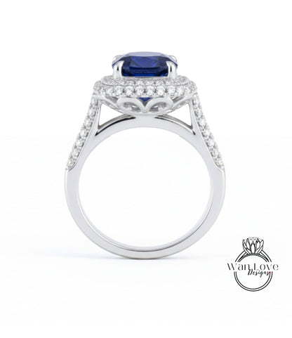 A silver ring with a large blue gemstone, likely a sapphire, set in a halo of smaller diamonds.