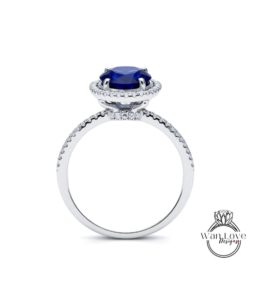 A silver ring with a large blue gemstone, likely a sapphire, at the center.