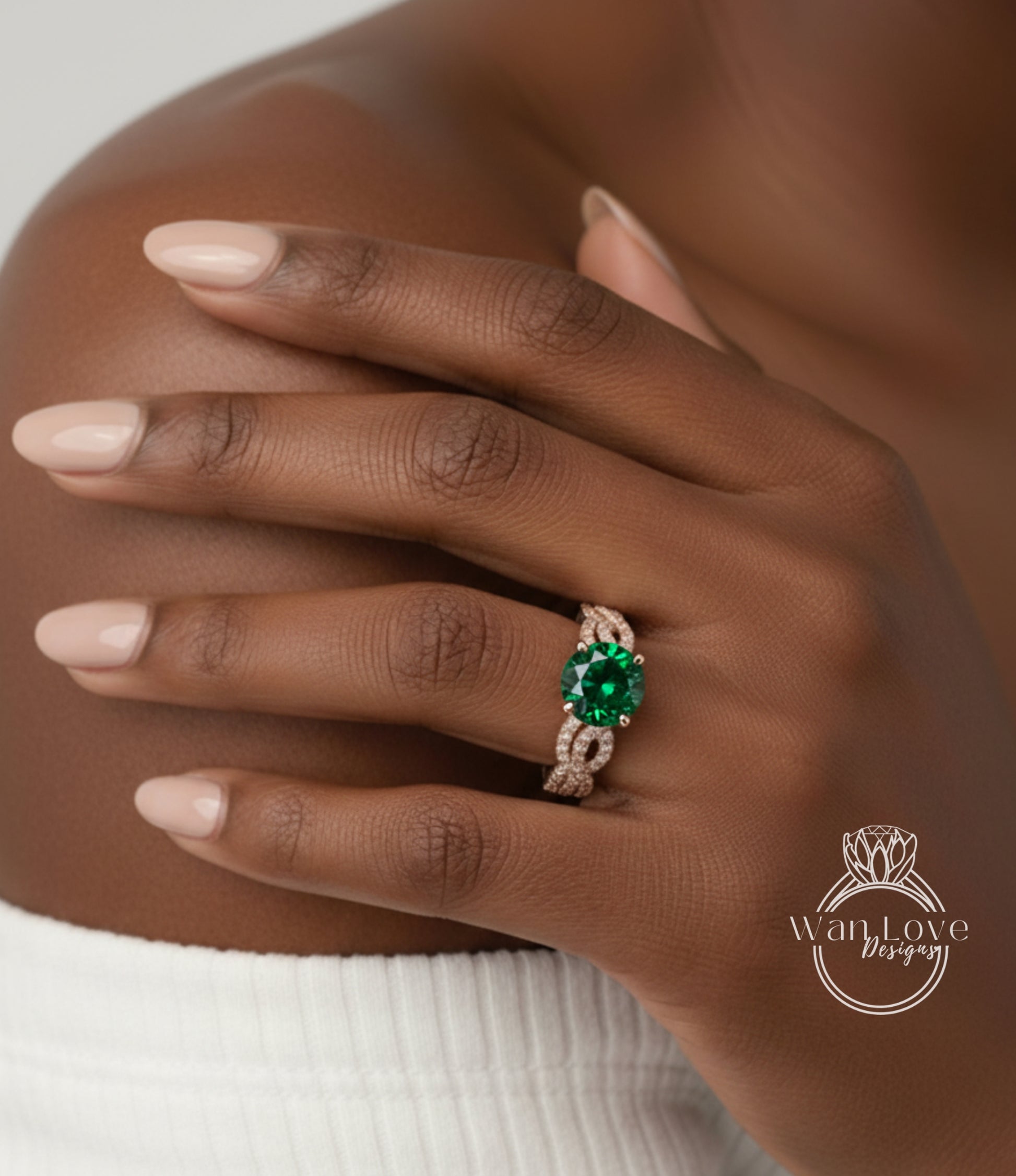 A close-up of a person's hand wearing a ring with a large green gemstone.