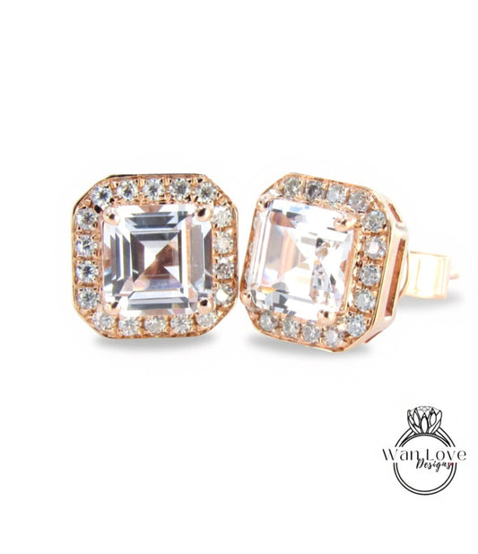 A pair of elegant gold earrings with large, clear gemstones set in a halo around the edges.