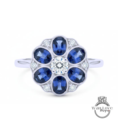 A silver ring with a large central diamond surrounded by smaller diamonds, set in a floral design.