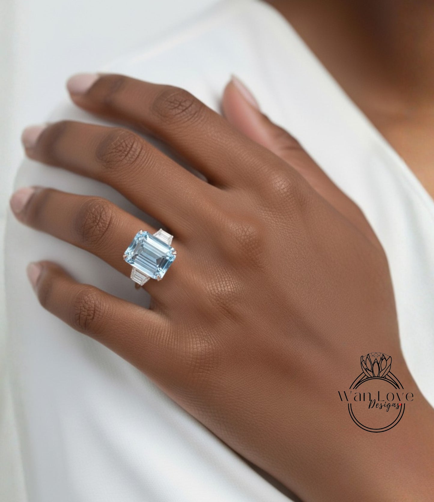 A close-up of a person's hand wearing a large, blue diamond ring on the ring finger.
