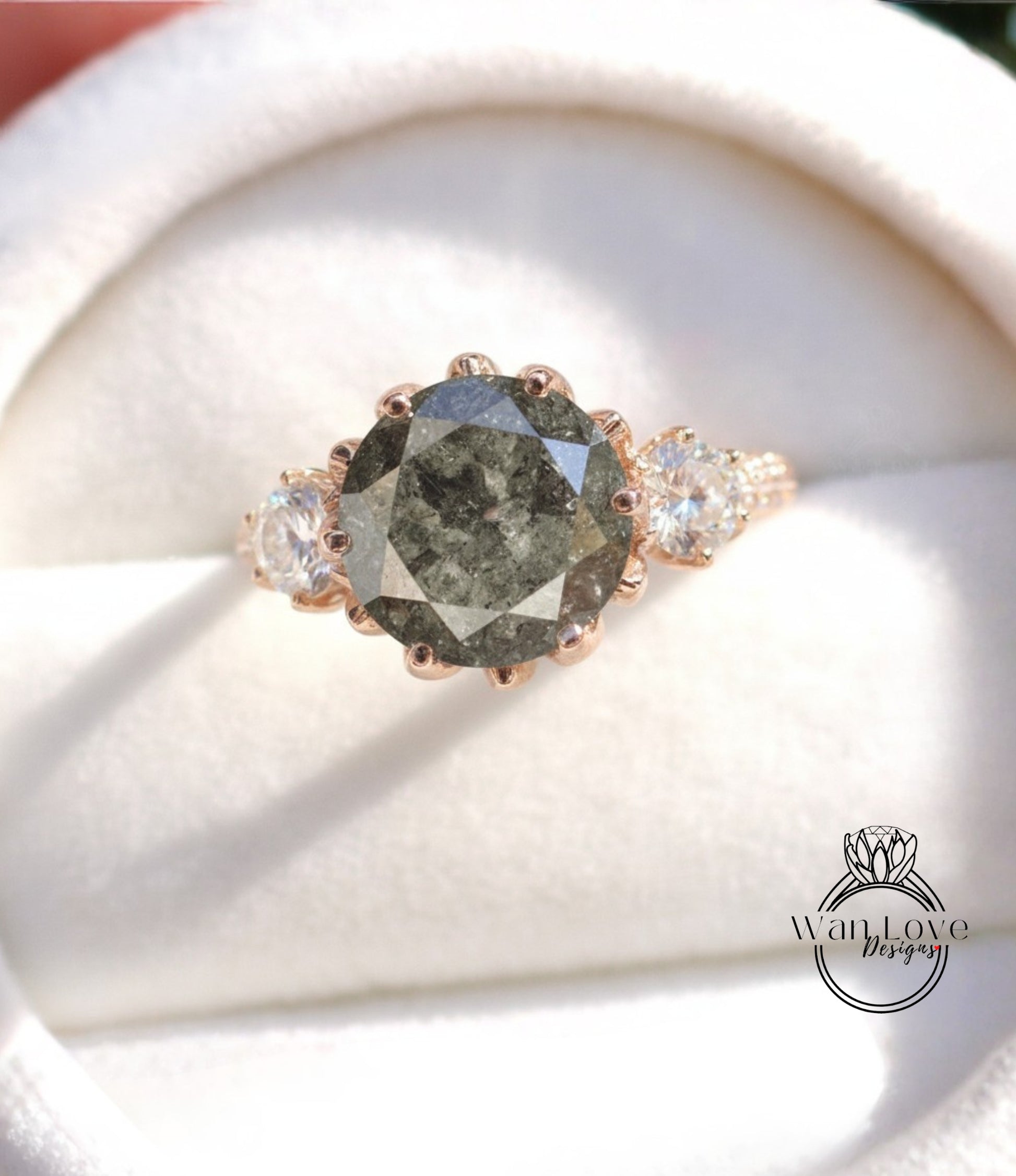 A close-up image of a gold ring with a large, dark gray diamond as the centerpiece, surrounded by smaller diamonds.