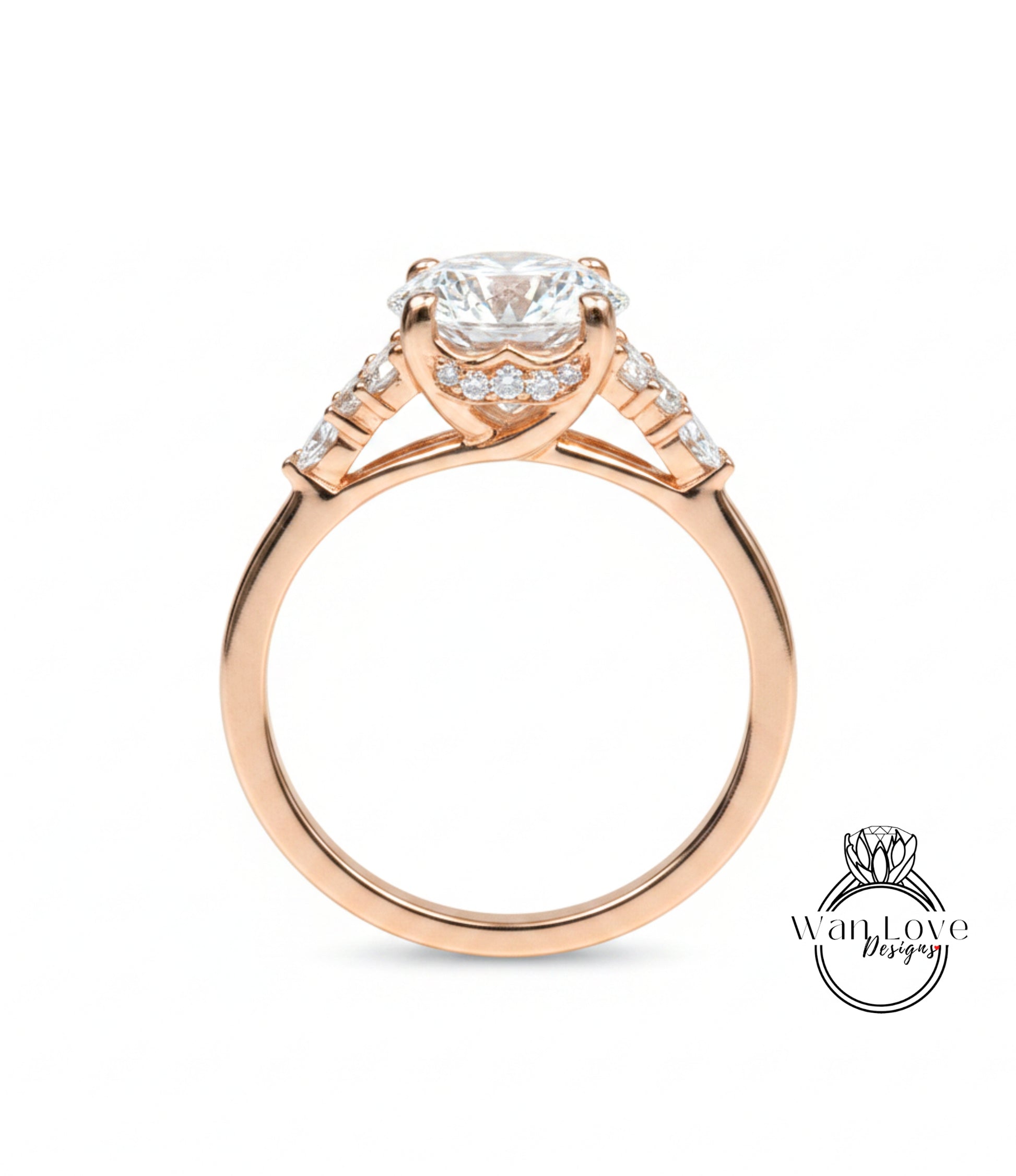 A close-up of a gold engagement ring with a large central diamond surrounded by smaller diamonds on either side.