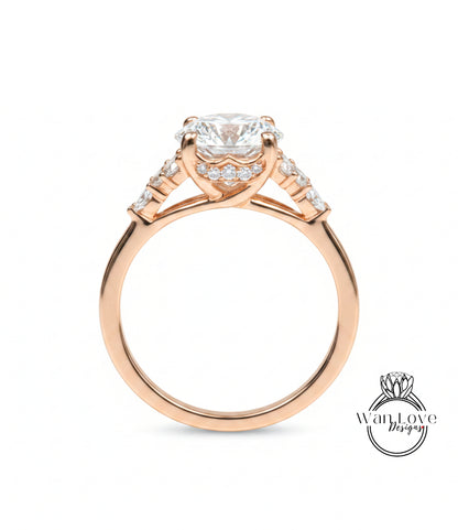 A close-up of a gold engagement ring with a large central diamond surrounded by smaller diamonds on either side.