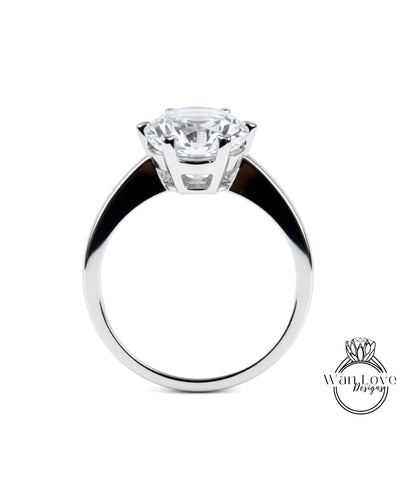 A close-up of a silver ring with a large, clear gemstone set in the center.