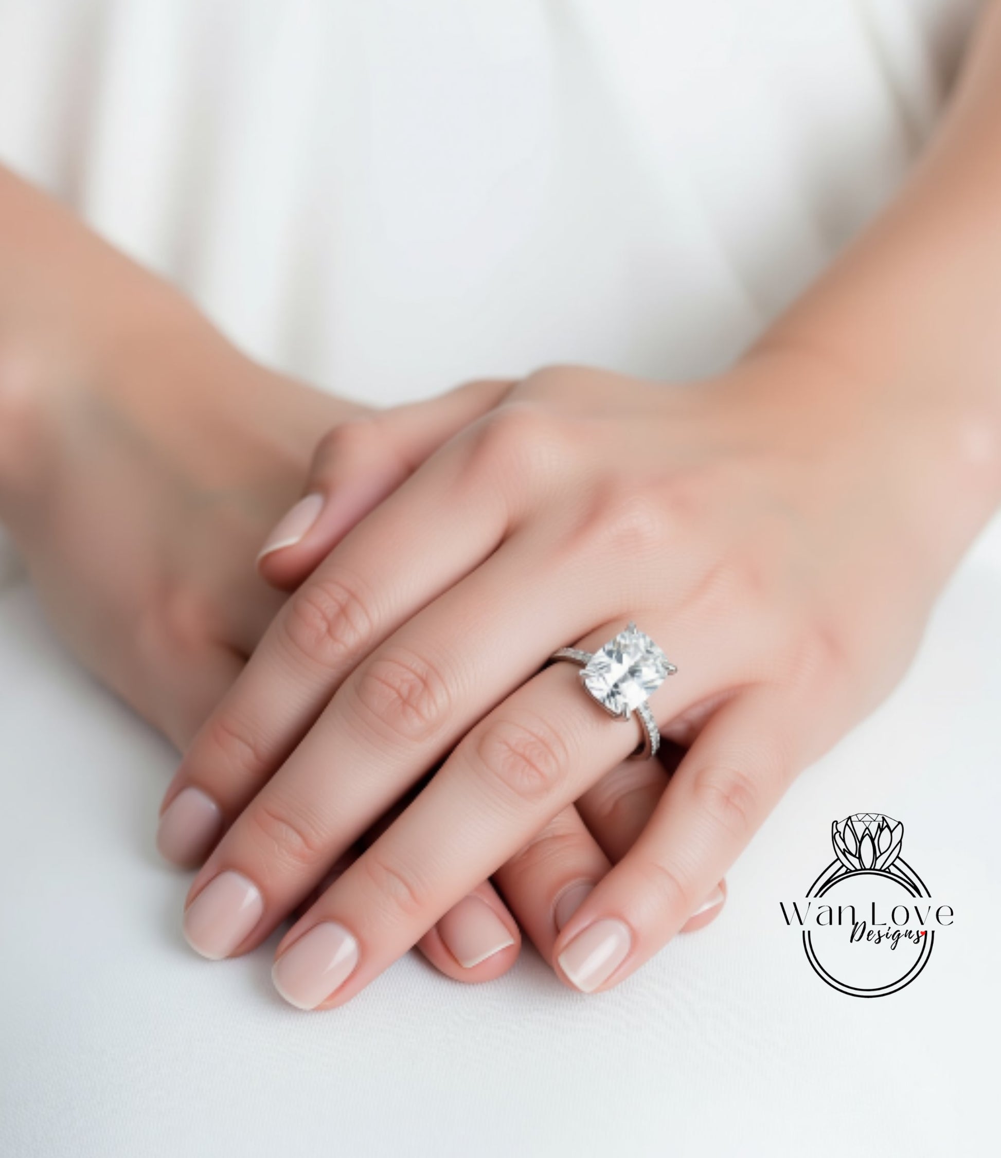 A close-up image of a person's hands wearing a large diamond engagement ring.
