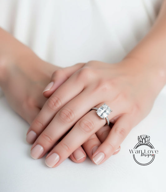 A close-up image of a person's hands wearing a large diamond engagement ring.