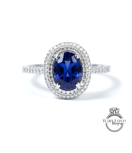 A stunning diamond ring with a large oval-shaped blue gemstone surrounded by a halo of smaller diamonds set in a silver band.