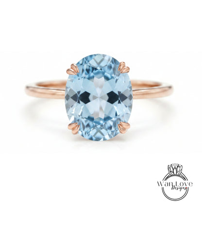 A rose gold ring with a large oval-shaped blue gemstone set in the center.