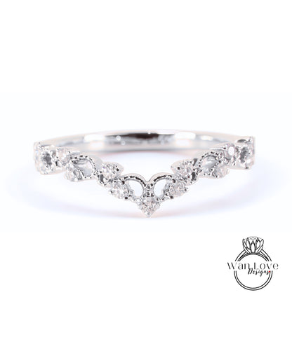 A silver ring with a heart-shaped design and numerous small diamonds set in it.