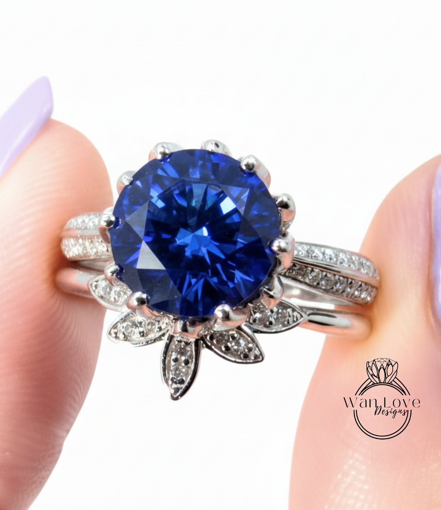 A close-up of a person's hand wearing a silver ring with a large blue gemstone, possibly a sapphire or blue topaz.