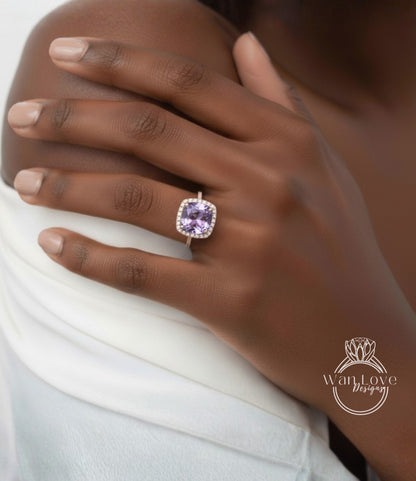 A close-up of a person's hand wearing a ring with a large purple gemstone.