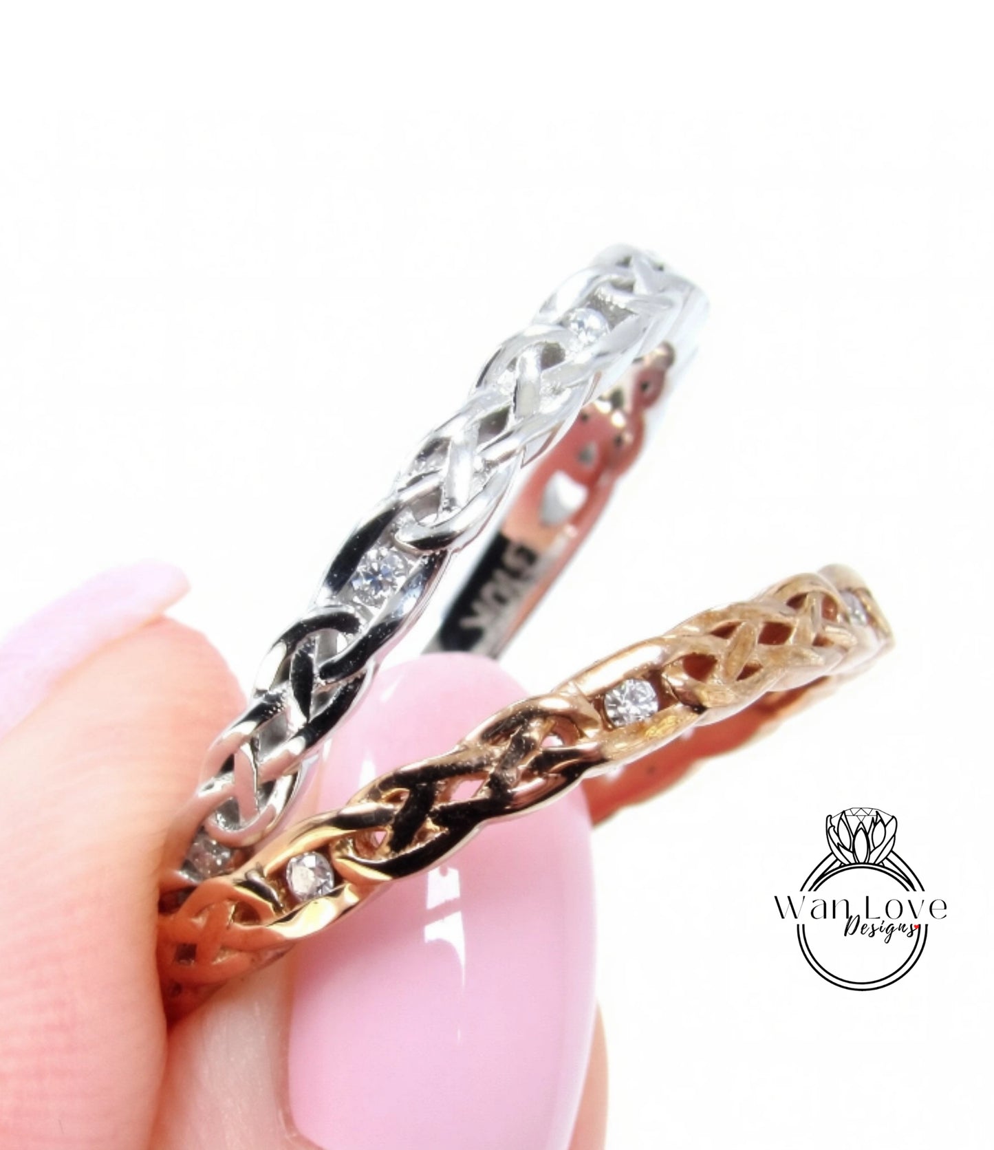 A close-up of a person's hand holding two rings, one silver and one gold, with intricate designs and small diamonds.