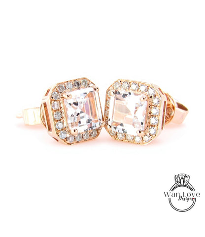 A pair of elegant gold earrings with large, clear gemstones set in a halo around the center.