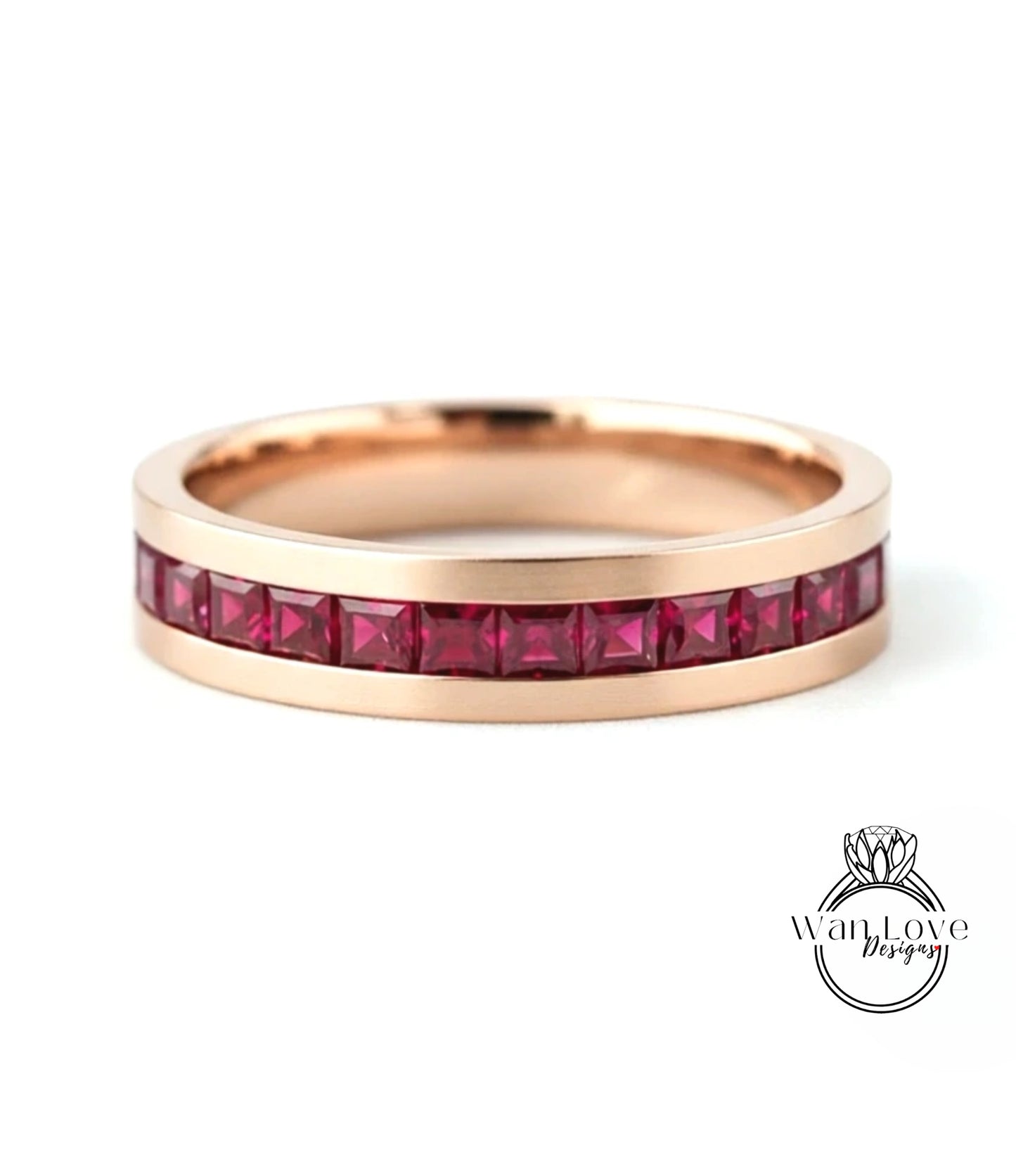 A gold-colored ring with a row of red gemstones, likely rubies, set in the band.