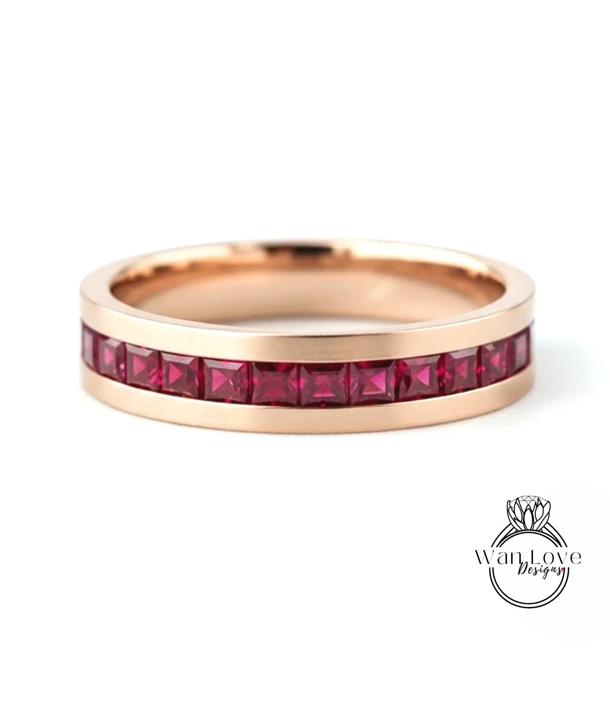 A gold-colored ring with a row of red gemstones, likely rubies, set in the band.