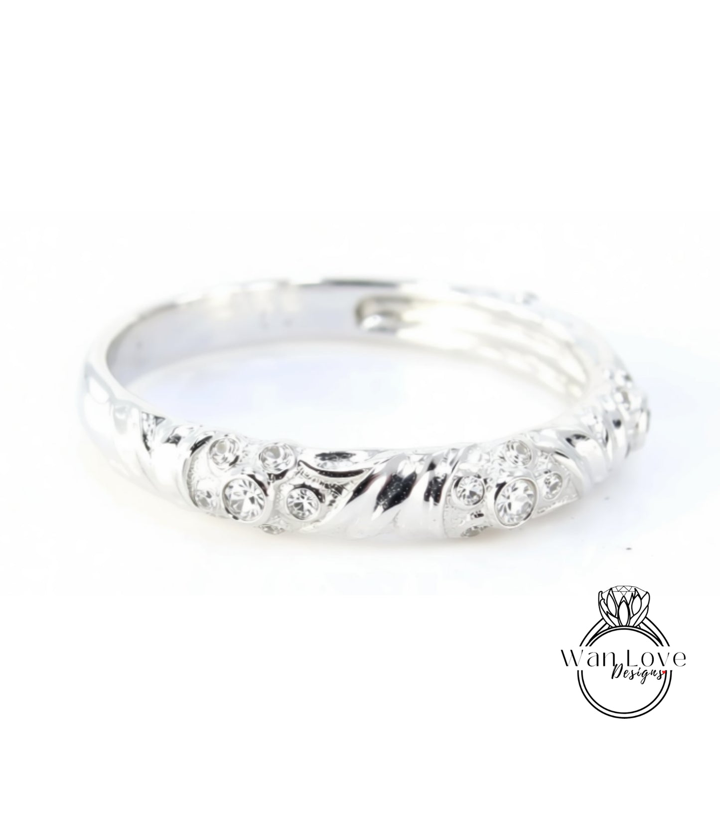 A silver ring with a decorative design featuring small diamonds.
