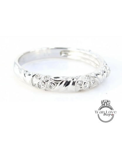 A silver ring with a decorative design featuring small diamonds.