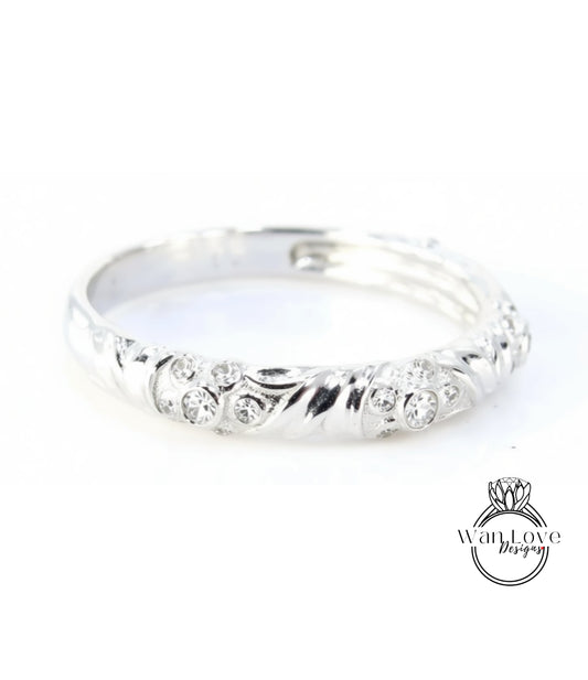 A silver ring with a decorative design featuring small diamonds.