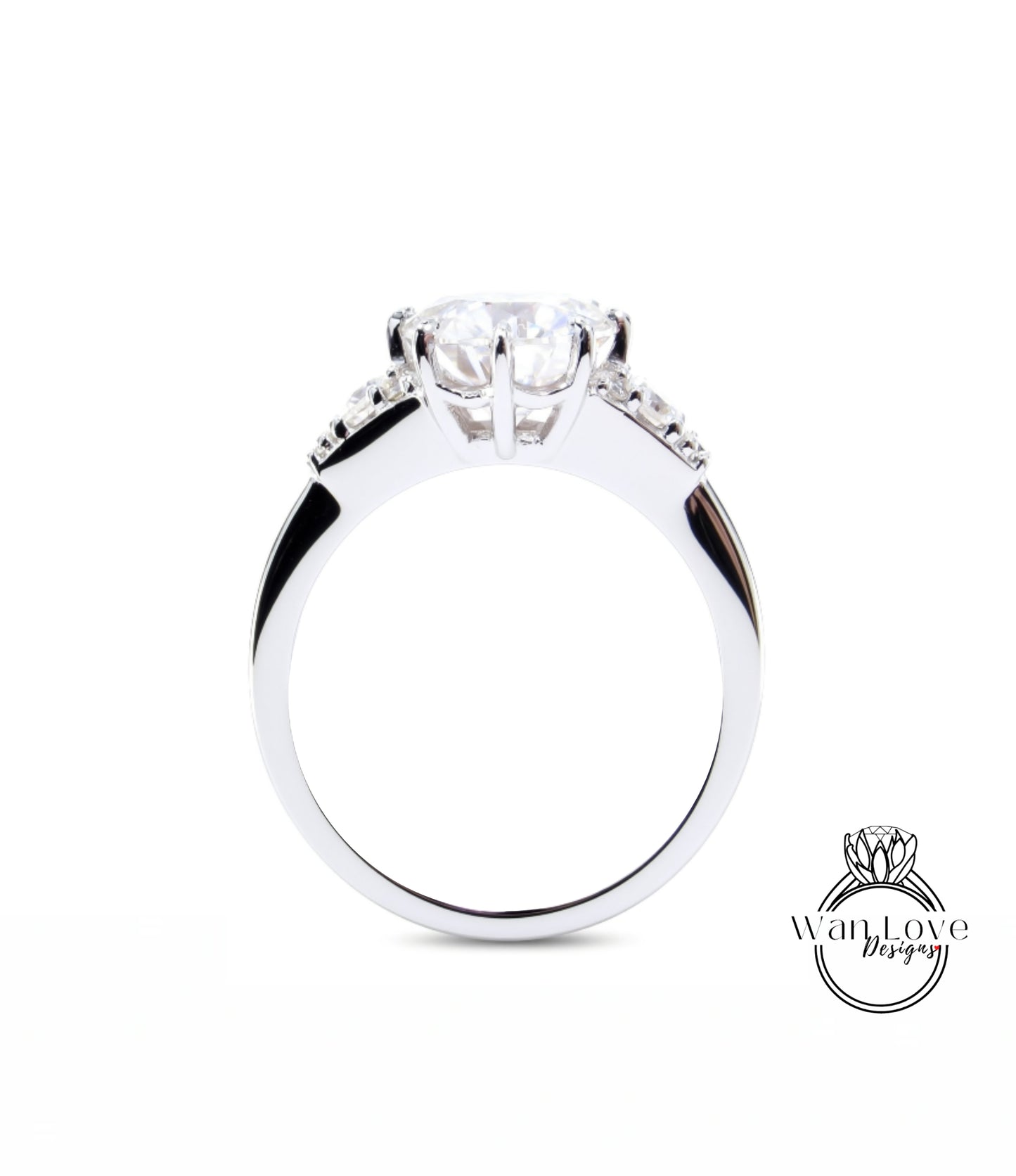 A close-up view of a silver engagement ring with a large central diamond and smaller diamonds on either side.