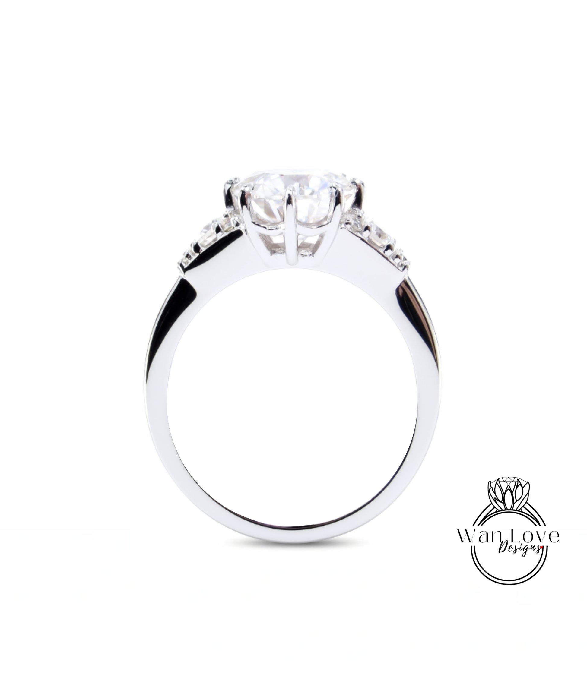 A close-up view of a silver engagement ring with a large central diamond and smaller diamonds on either side.