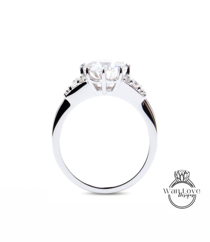A close-up view of a silver engagement ring with a large central diamond and smaller diamonds on either side.