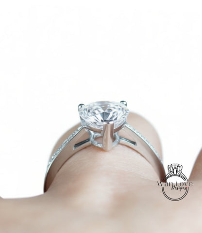 A close-up view of a diamond engagement ring on a person's hand.