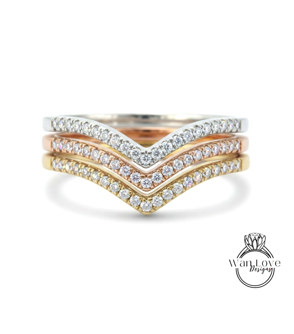 A ring with a diamond band featuring three different colored diamonds arranged in a v-shape.