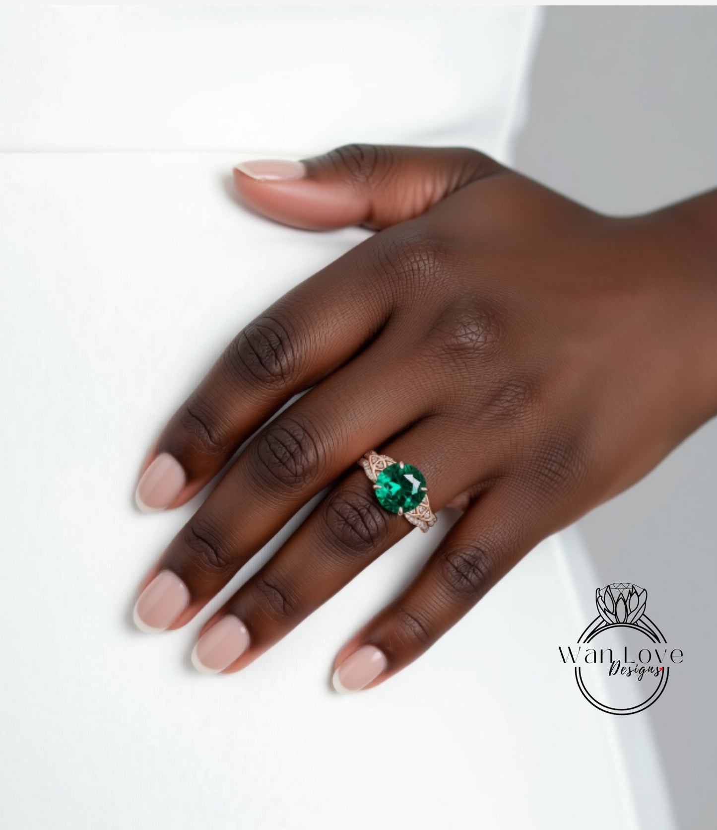 A close-up of a hand wearing a large, green gemstone ring against a white background.