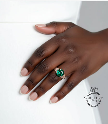 A close-up of a hand wearing a large, green gemstone ring against a white background.