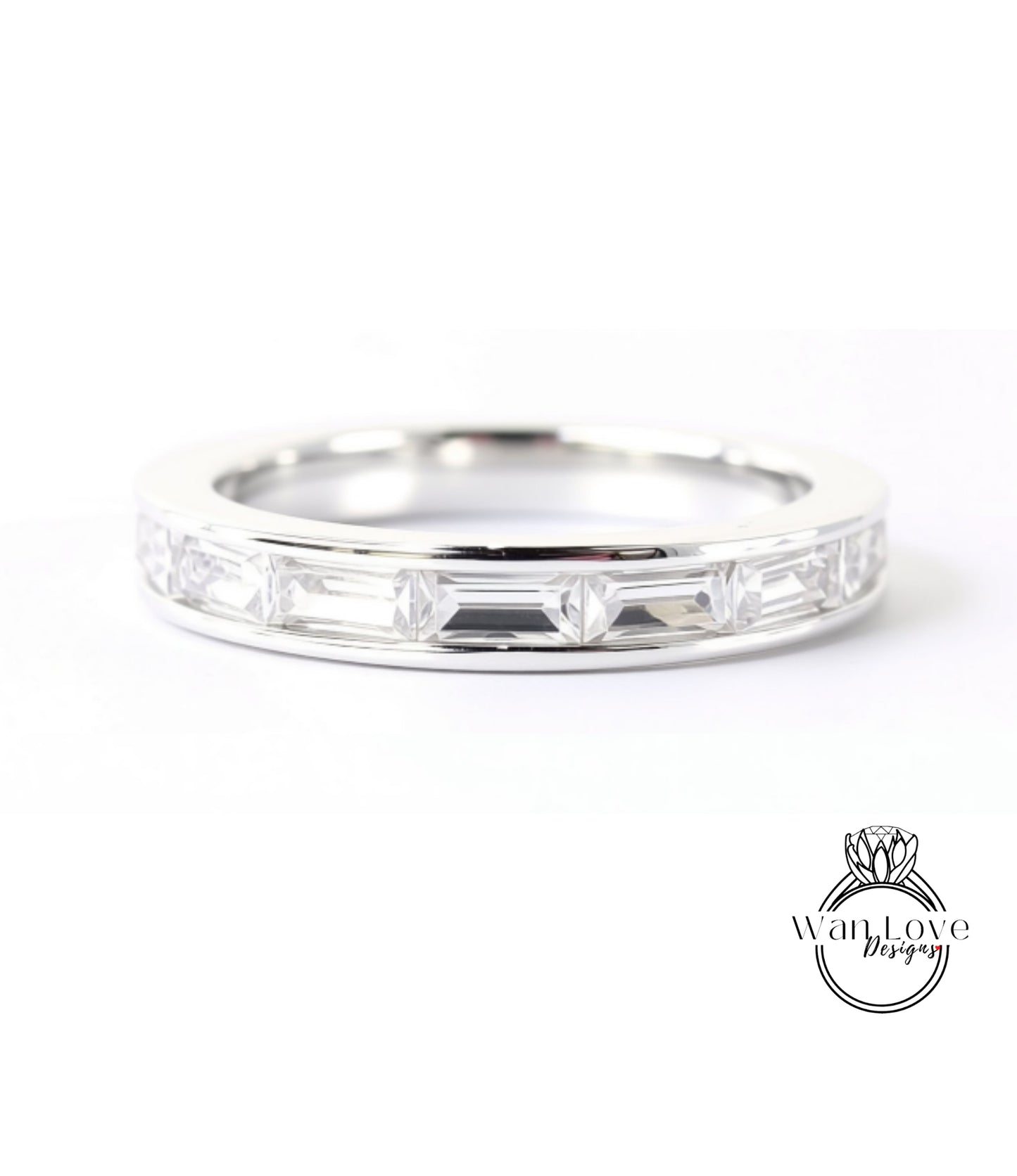 A silver ring with a row of clear gemstones, likely diamonds, set in a band.