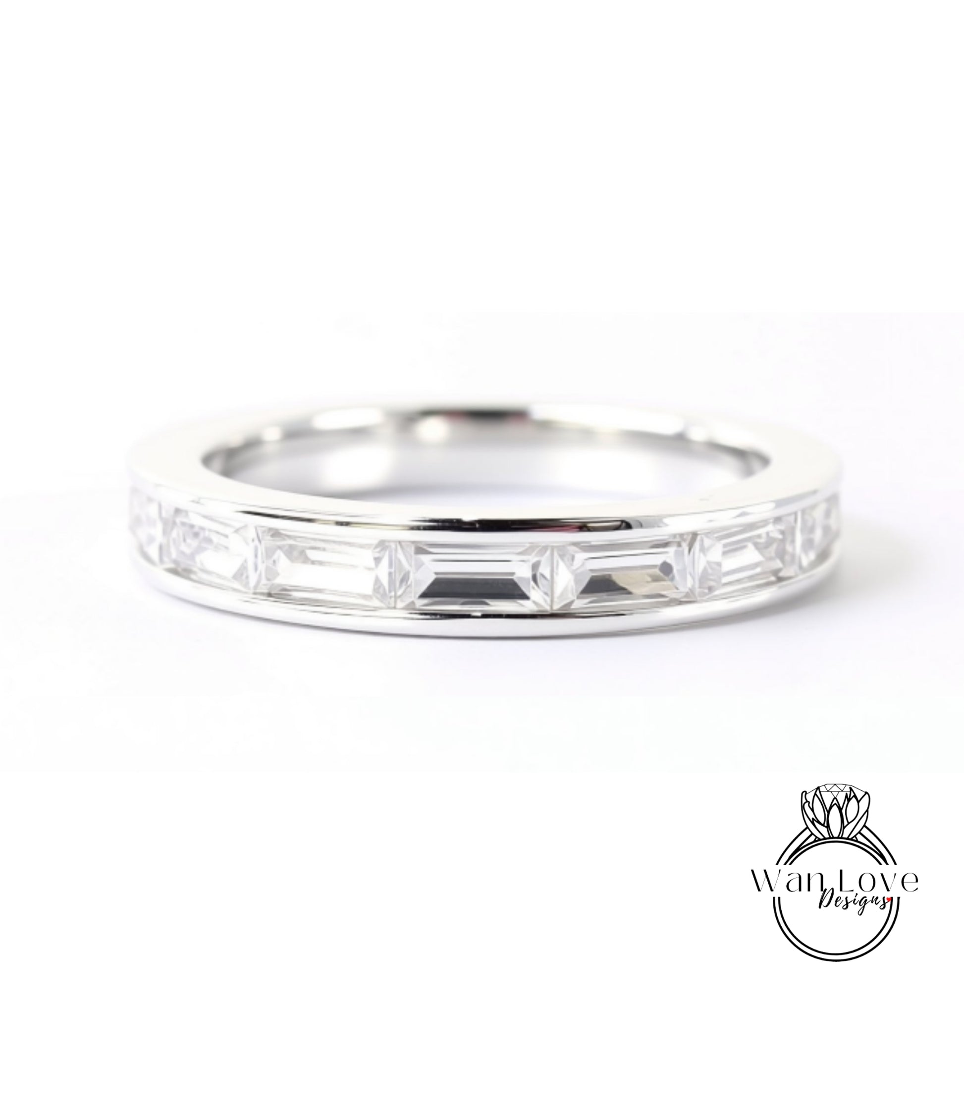 A silver ring with a row of clear gemstones, likely diamonds, set in a band.