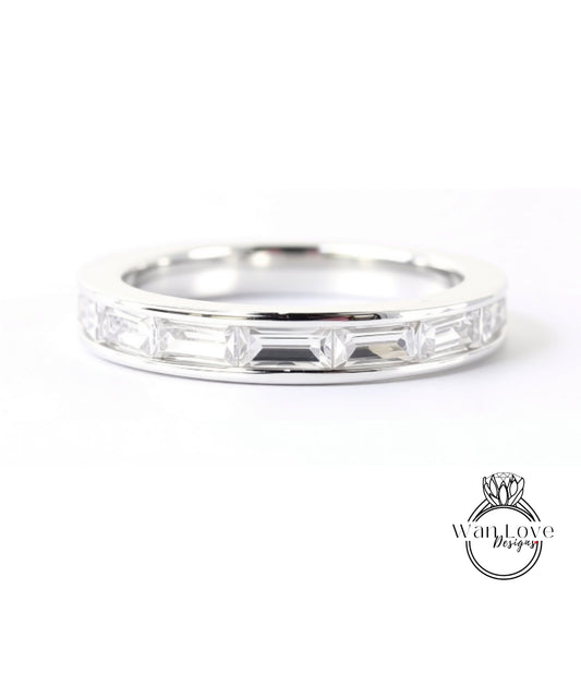 A silver ring with a row of clear gemstones, likely diamonds, set in a band.