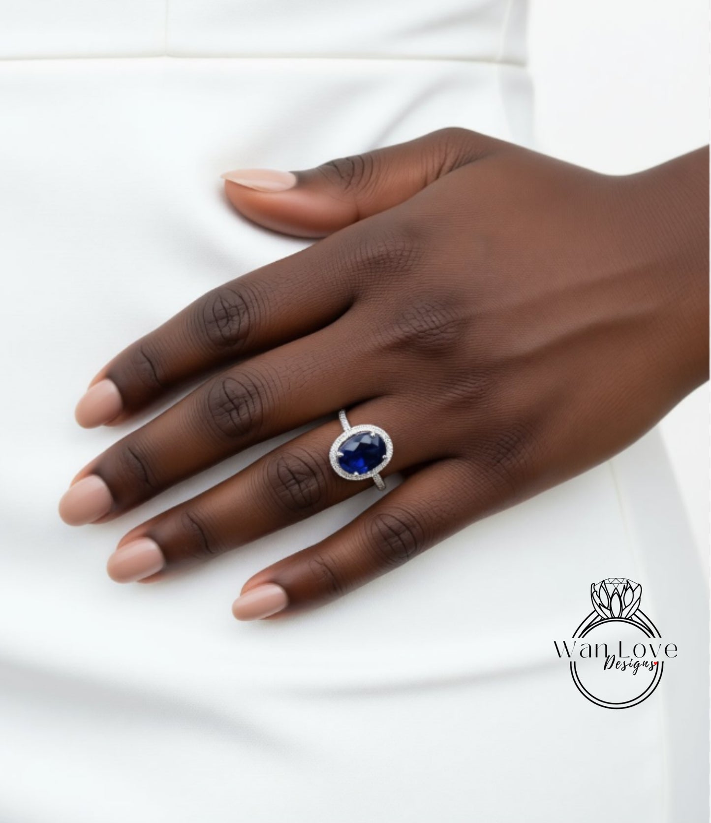 A close-up of a hand wearing a ring with a large blue gemstone.