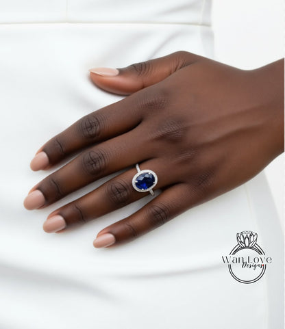 A close-up of a hand wearing a ring with a large blue gemstone.