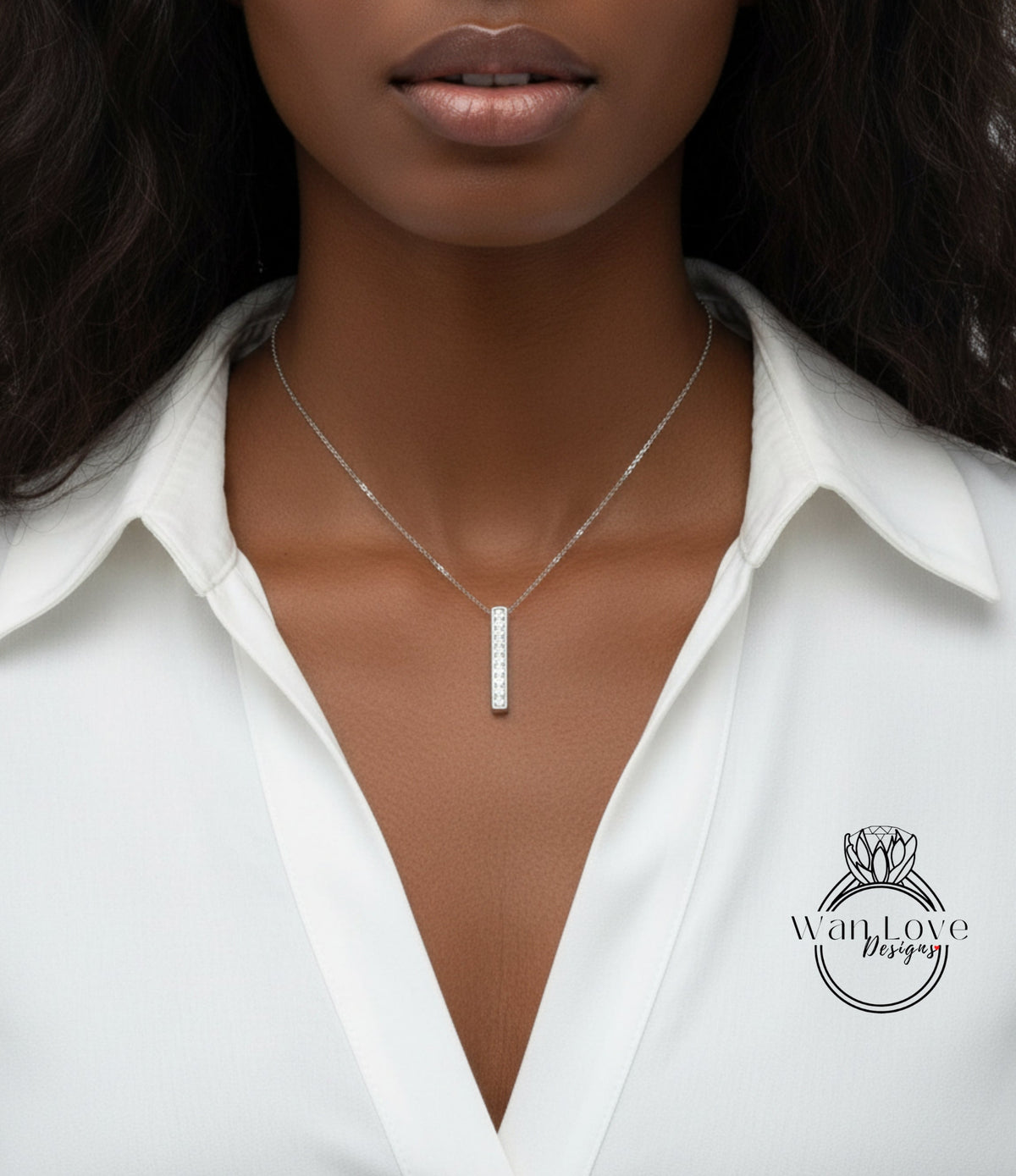 A close-up of a woman wearing a white blouse and a necklace with a pendant.