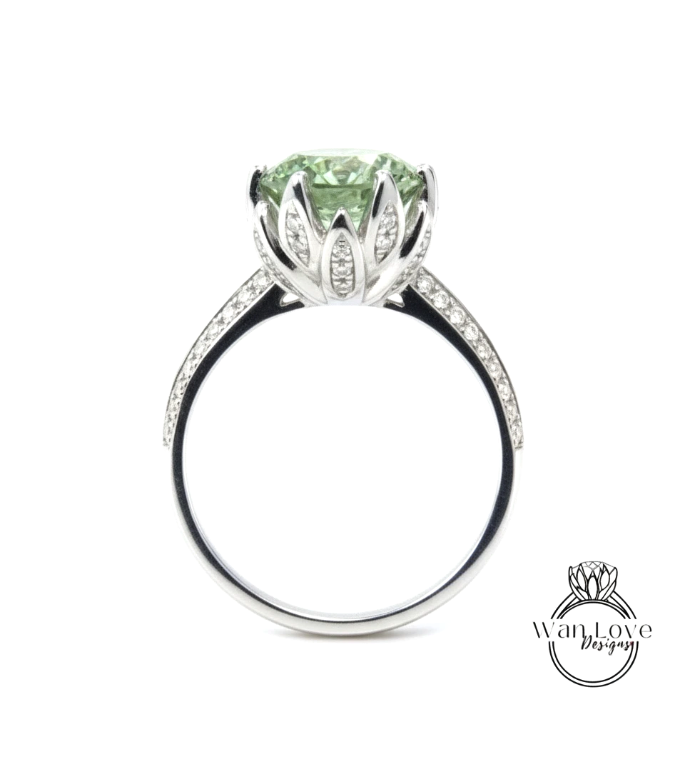 A silver ring with a large, green gemstone set in a decorative flower-like design.