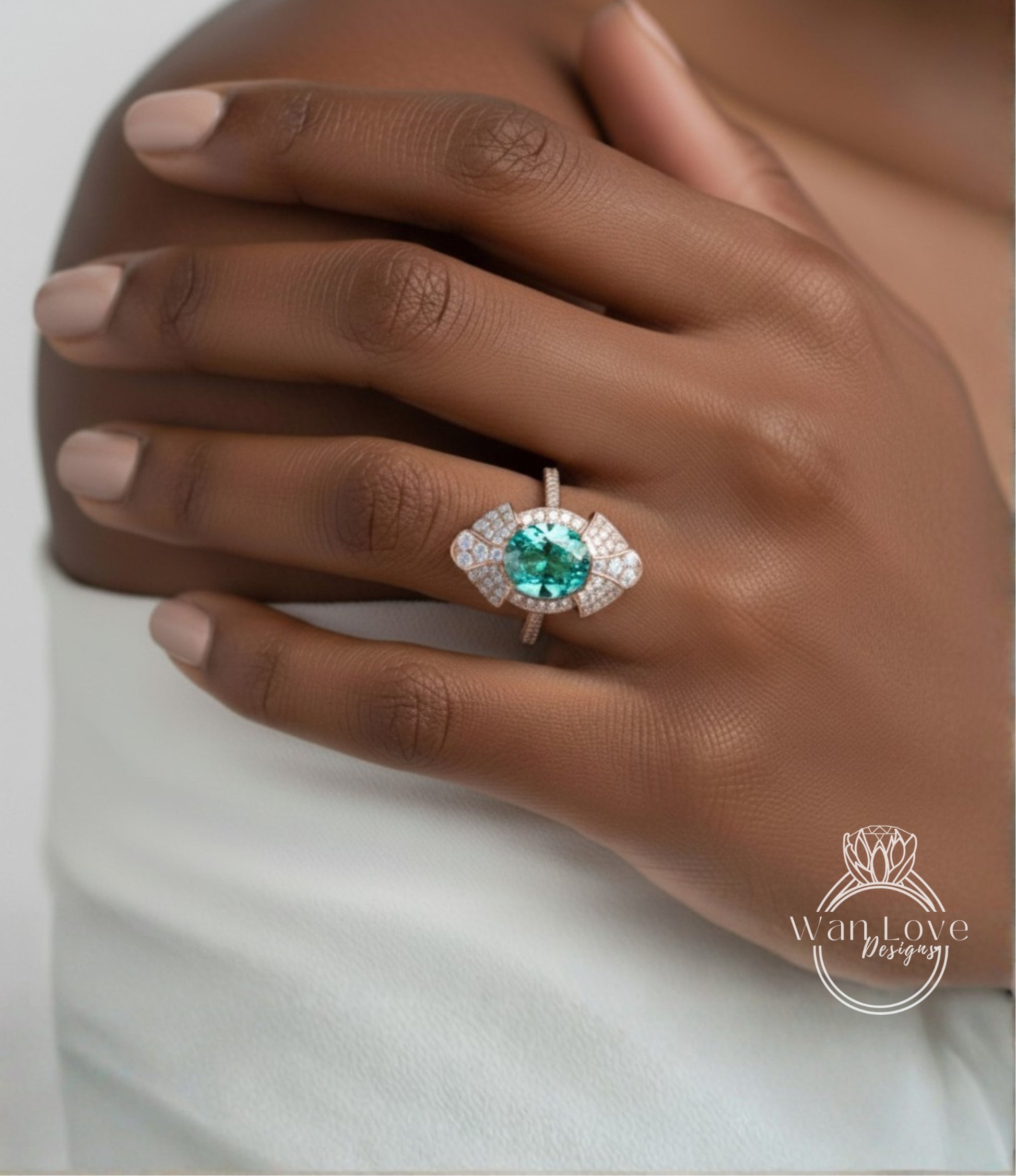 A close-up of a person's hand wearing a large, ornate ring with a large, green gemstone.