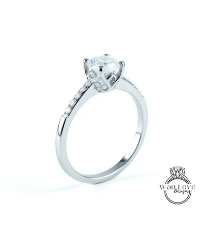 A silver engagement ring with a large central diamond and a smaller diamond accent on the band.