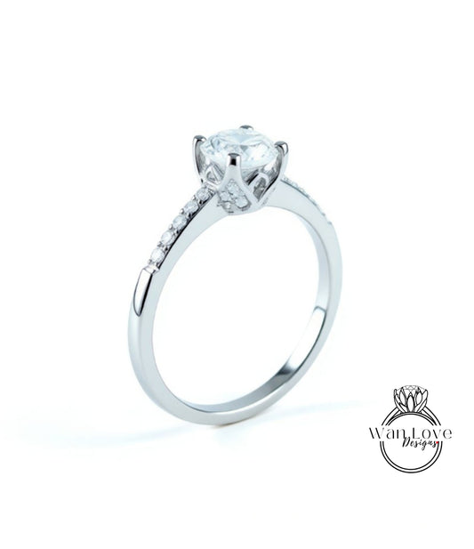A silver engagement ring with a large central diamond and a smaller diamond accent on the band.