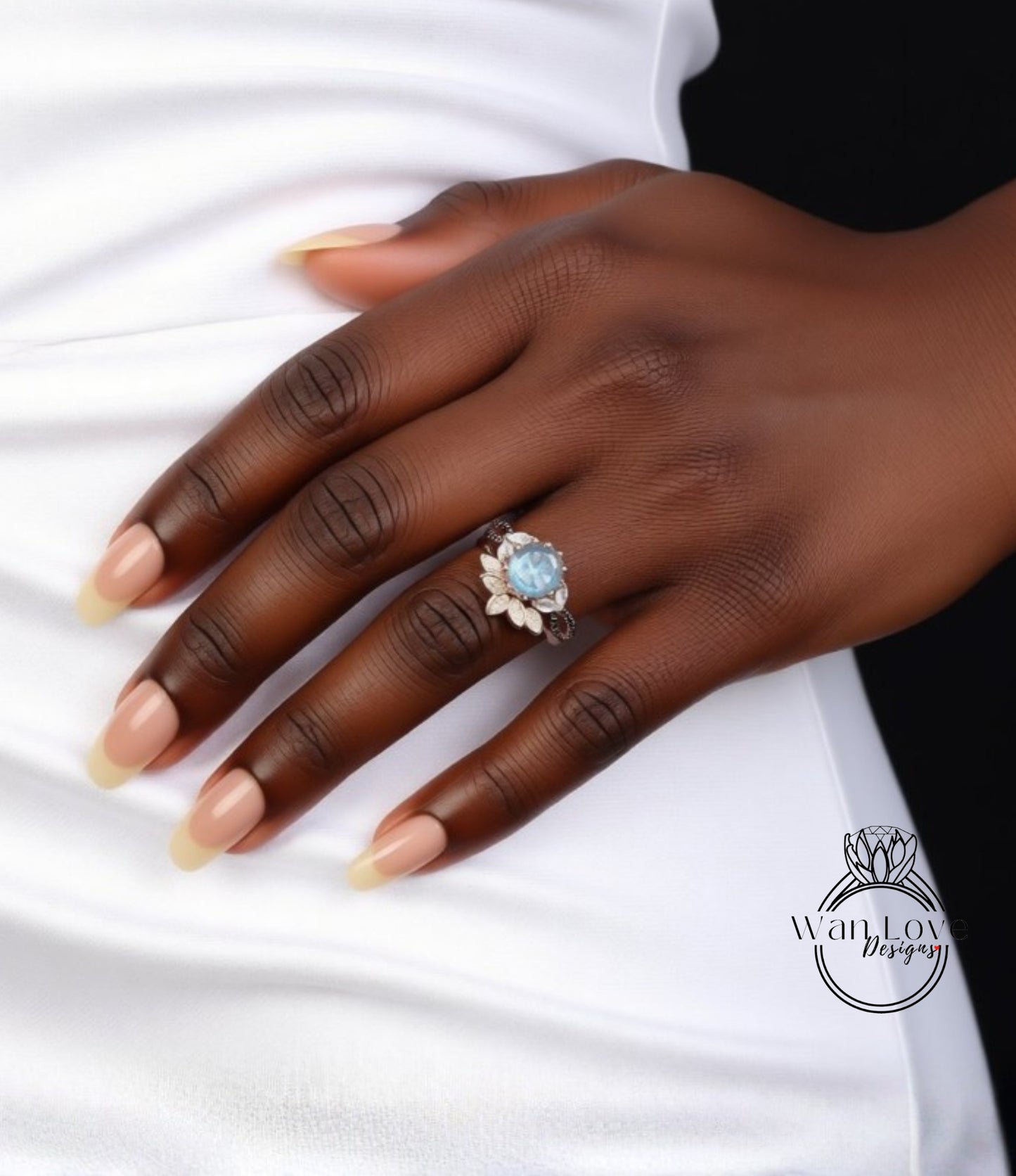 A close-up of a person's hand wearing a ring with a blue gemstone.