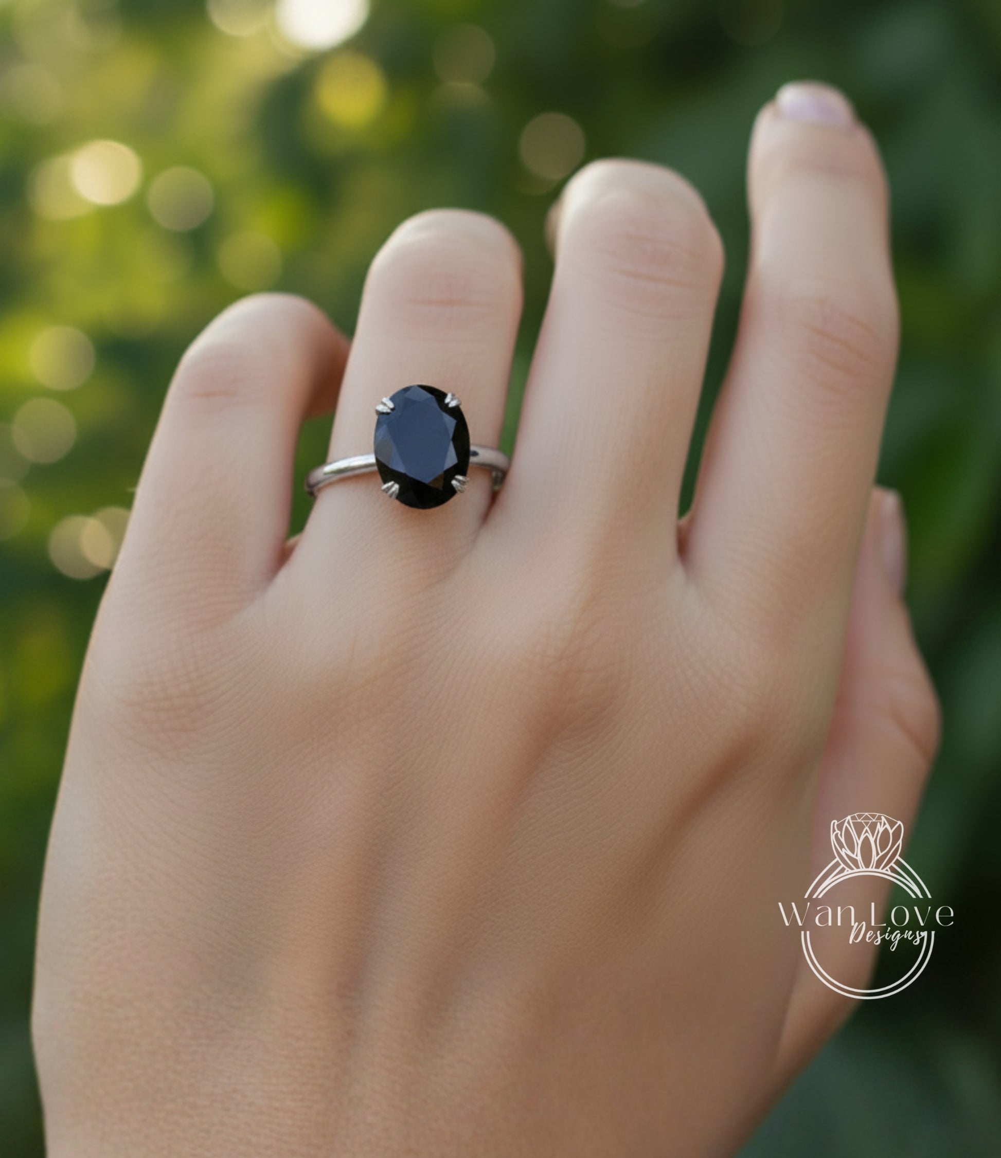 A close-up of a person's hand wearing a ring with a large black gemstone.