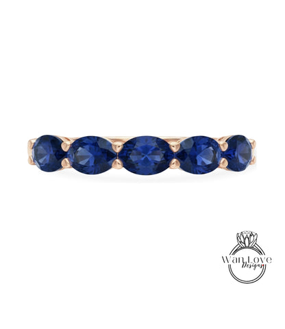 A gold ring with a row of blue sapphire gemstones.