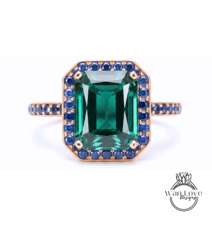 A large, rectangular green gemstone set in a gold ring with a blue gemstone border.