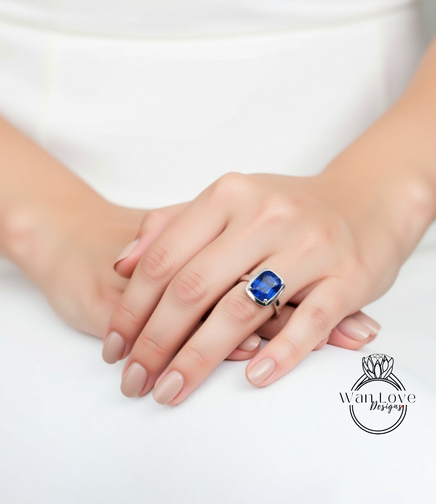 A close-up of a person's hand wearing a ring with a large blue gemstone.