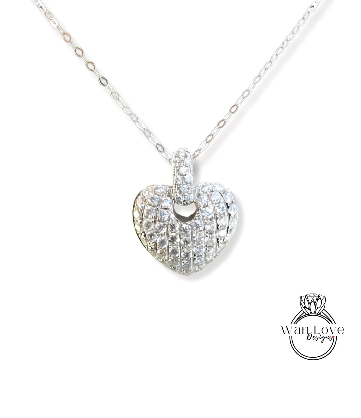 A silver necklace with a heart-shaped pendant adorned with numerous small diamonds.