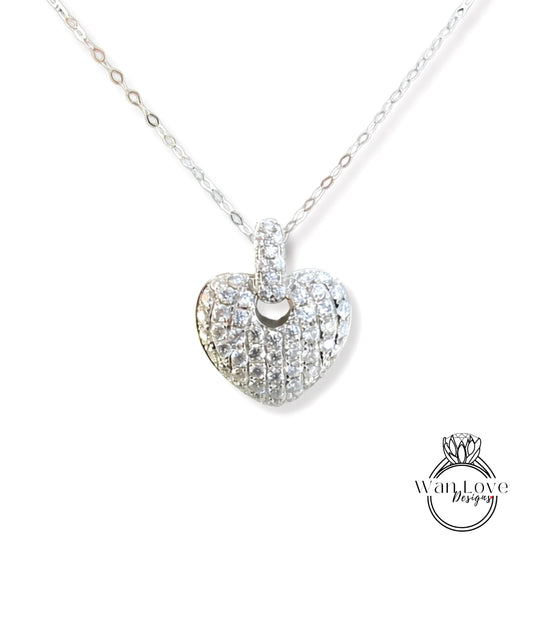 A silver necklace with a heart-shaped pendant adorned with numerous small diamonds.